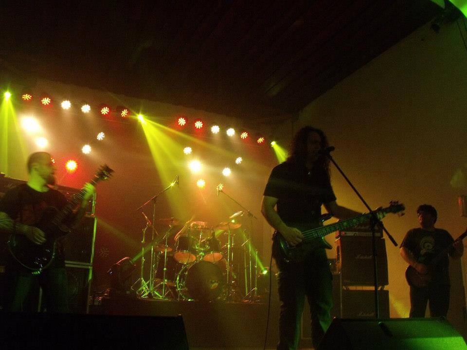 Victims of Creation performing live under green and amber stage light